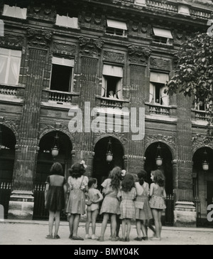 COLETTE - French novelist (1873-1954) waves to local children from her Paris apartment Stock Photo