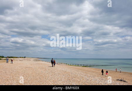 People walking on Climping Beach in West Sussex. Stock Photo