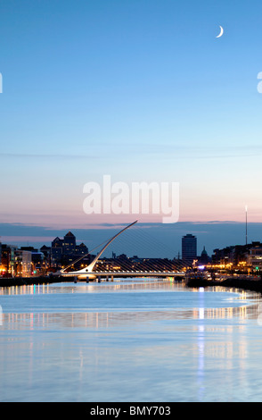 Samuel Beckett Bridge, spanning the River Liifey in Dublin illuminated at night with the moon in the sky Stock Photo