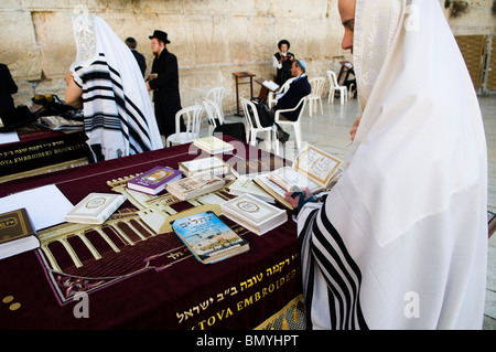 A Jewish man praying at the wailing wall in the old city of Jerusalem. he is wearing a Talit and he has Tfilin on his hand. Stock Photo