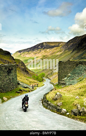 Motorcyclist on road trip through a mountain road over Honister Pass in the Lake District, England, UK Stock Photo