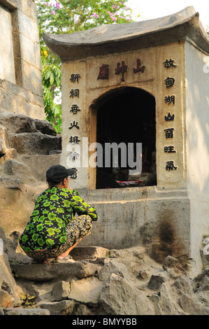 Buddhist believer in front of shrine, Hanoi, Vietnam Stock Photo