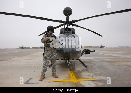 An OH-58D Kiowa Warrior pilot stands beside his aircraft. Stock Photo