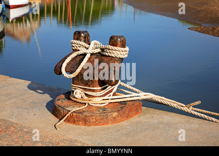 Bollard with mooring ropes attached on the quayside at Blakeney, Norfolk, England, United Kingdom. Stock Photo