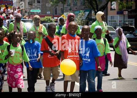 Participants march in the Juneteenth celebration parade through the streets of Harlem in New York Stock Photo