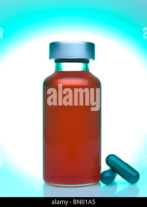 Close up of a vial full of red liquid, green pills aside. Stock Photo