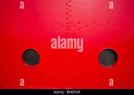 A close-up view of Big Red lighthouse wall with two small round circle windows in Holland Michigan hi-res Stock Photo