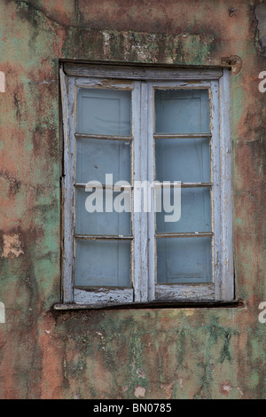 White Faded Wood Window on a multi-colored Wall Stock Photo