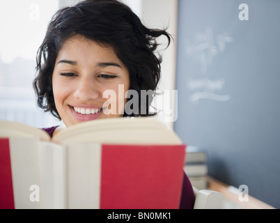 Hispanic woman reading book Stock Photo