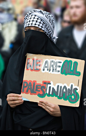 A young woman dresses in the Islamic niqab holds up a home made placard during a demonstration against the Israeli blockade of Gaza 2010 Stock Photo