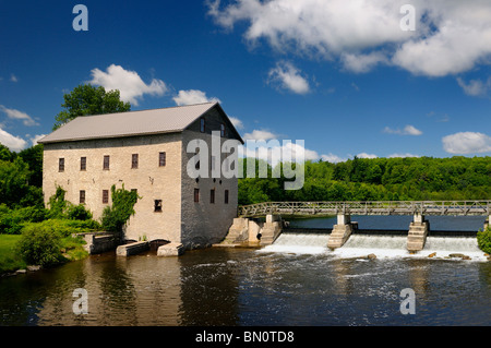 Lang Grist Mill and bridge over waterfall dam at Pioneer Village on the Indian River Ontario Keene Ontario Canada Stock Photo