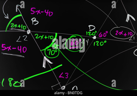 Several complex mathematical formulas, equations, and geometry written on a smooth black board. Stock Photo