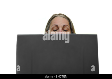 Woman typing on a laptop with her eyes looking down at the keyboard Stock Photo