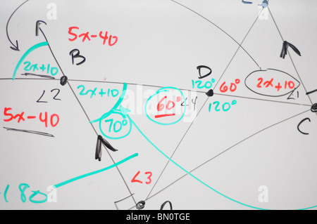 Several complex mathematical formulas, equations, and geometry written on a white board. Stock Photo