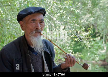 Portrait bearded man smoking bamboo pipe Shiguzhen Yunnan China Stock Photo