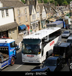 Traffic congestion in the Cotswolds town of Burford Oxfordshire where a tour bus and grain lorry are almost locked togethe Stock Photo