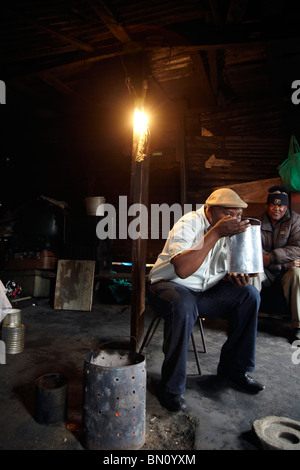 black man drinking home brew in Shebeen She Been Stock Photo