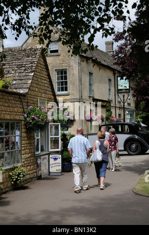 Tourists in Bourton on the Water a popular riverside village which stands on the River Windrush in Gloucestershire England UK Stock Photo