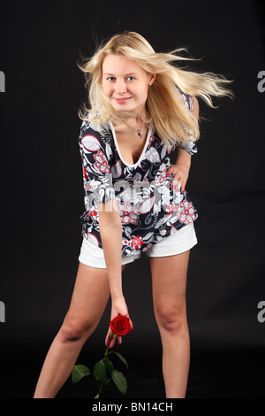 Young blonde woman with red rose. Stock Photo