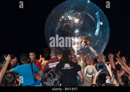 Profile view of Wayne Coyne, front man of the The Flaming Lips rock band, crowd surf in a giant see through transparent zorbing ball with the crowd going wild below him at Glastonbury Music Festival, at The Other stage, 2010 Stock Photo