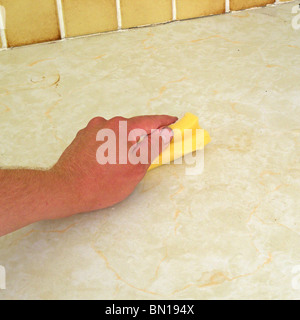 Caucasian Male Wiping up Mess on a Kitchen Work Surface, UK MODEL RELEASED Stock Photo