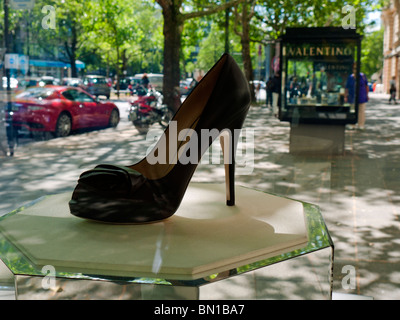 Luxury designer shoes on display in glass cabinet outside Louis