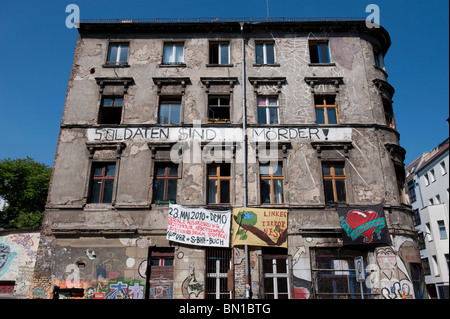 Old apartment building with squatters living inside and protest banners hanging on wall in Mitte Berlin Germany Stock Photo
