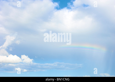 Rainbow in blue sky with few clouds Stock Photo - Alamy