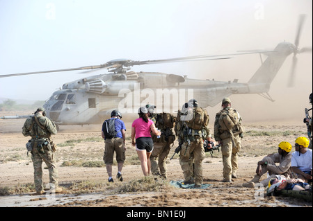 A team of Air Force pararescuemen transports the injured to a waiting U.S. Marine Corps MH-53 Super Stallion helicopter Stock Photo