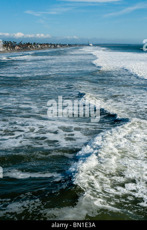 View of ocean waves from Oceanside pier with Carlsbad Encina power plant in distance, Oceanside, California, USA. Stock Photo
