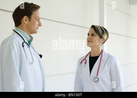 Doctors chatting together in hospital corridor Stock Photo