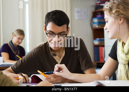 Classmates working on mathematics assignment together Stock Photo