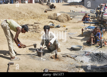 wandering blacksmiths (Lohepitas) are working on iron to make axe. Stock Photo