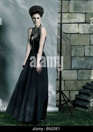 Standing Woman Wearing Black Dress And Black Boots Stock Photo