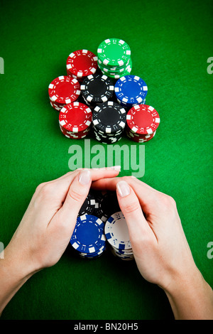 Female hands rakes up stack of gambling chips Stock Photo