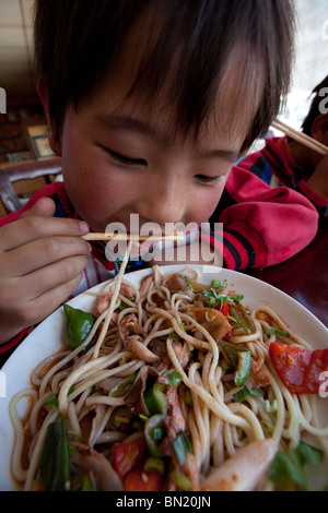 Boy eating noodles in Shigatse, Tibet Stock Photo
