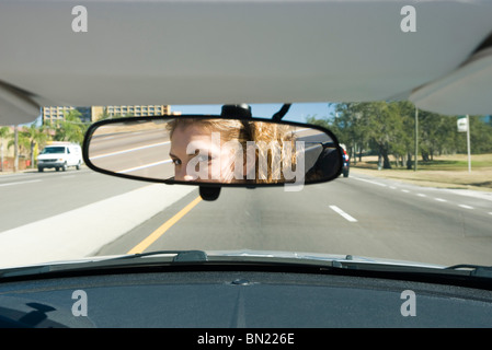 Woman driving, checking rear view mirror Stock Photo