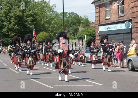 Epping Forest Pipe Band leads the North East London “Armed Forces Day” Parade, Station Road, Chingford, London Borough of Waltha Stock Photo