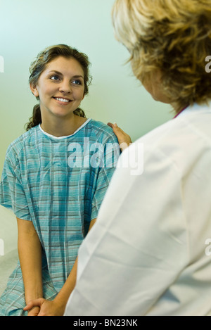 Patient smiling with relief while receiving good news from doctor Stock Photo