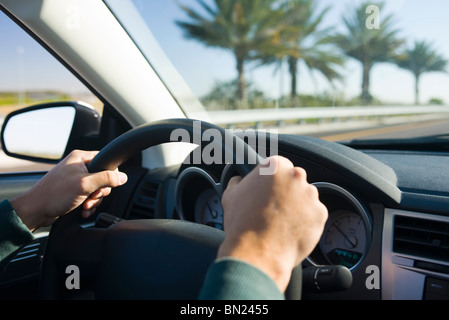 Driving with both hands on steering wheel Stock Photo