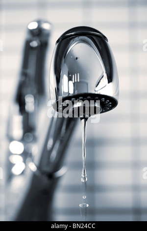 Water dripping from stainless steel kitchen faucet Stock Photo
