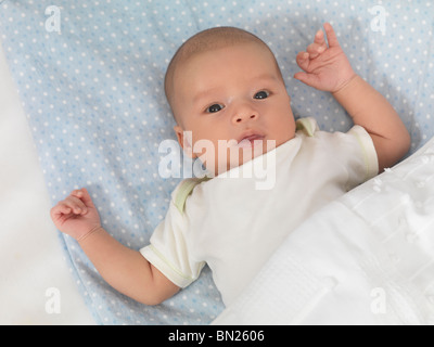 Six week old cute baby boy lying in a crib Stock Photo