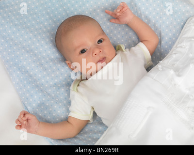 Six week old cute baby boy lying in a crib Stock Photo