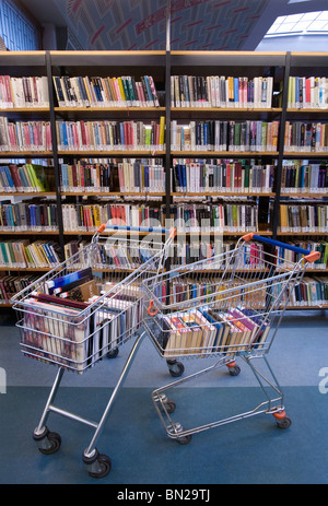 Pile of books by empty shelves hi-res stock photography and images - Alamy