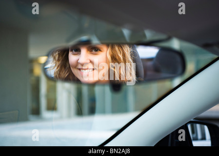 Woman's face reflected in rearview mirror Stock Photo