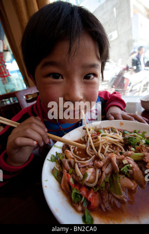 Boy eating noodles in Shigatse, Tibet Stock Photo