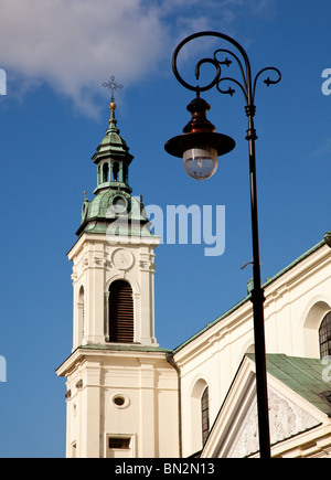 Old ornate lanterns in front of the tower of an old church in Warsaw Poland Stock Photo