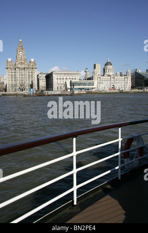 City of Liverpool, England. The Three Graces at Liverpool’s Pier Head waterfront with the Mersey Ferry in the foreground. Stock Photo