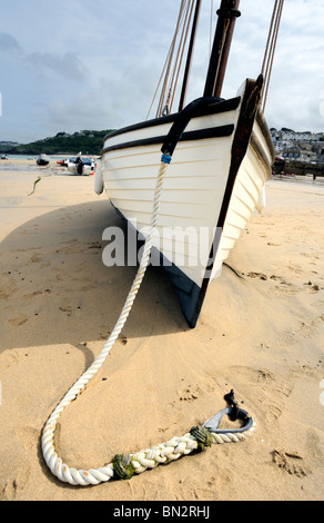 Old wooden sailing boat lying on the sand at low tide Stock Photo