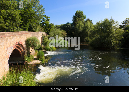 Fast flowing water over a weir under the Harrold road bridge, Bedfordshire, UK Stock Photo